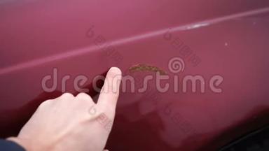人在汽车油漆中表现出生锈的<strong>划痕</strong>。 手指显示红色汽车的<strong>划痕</strong>